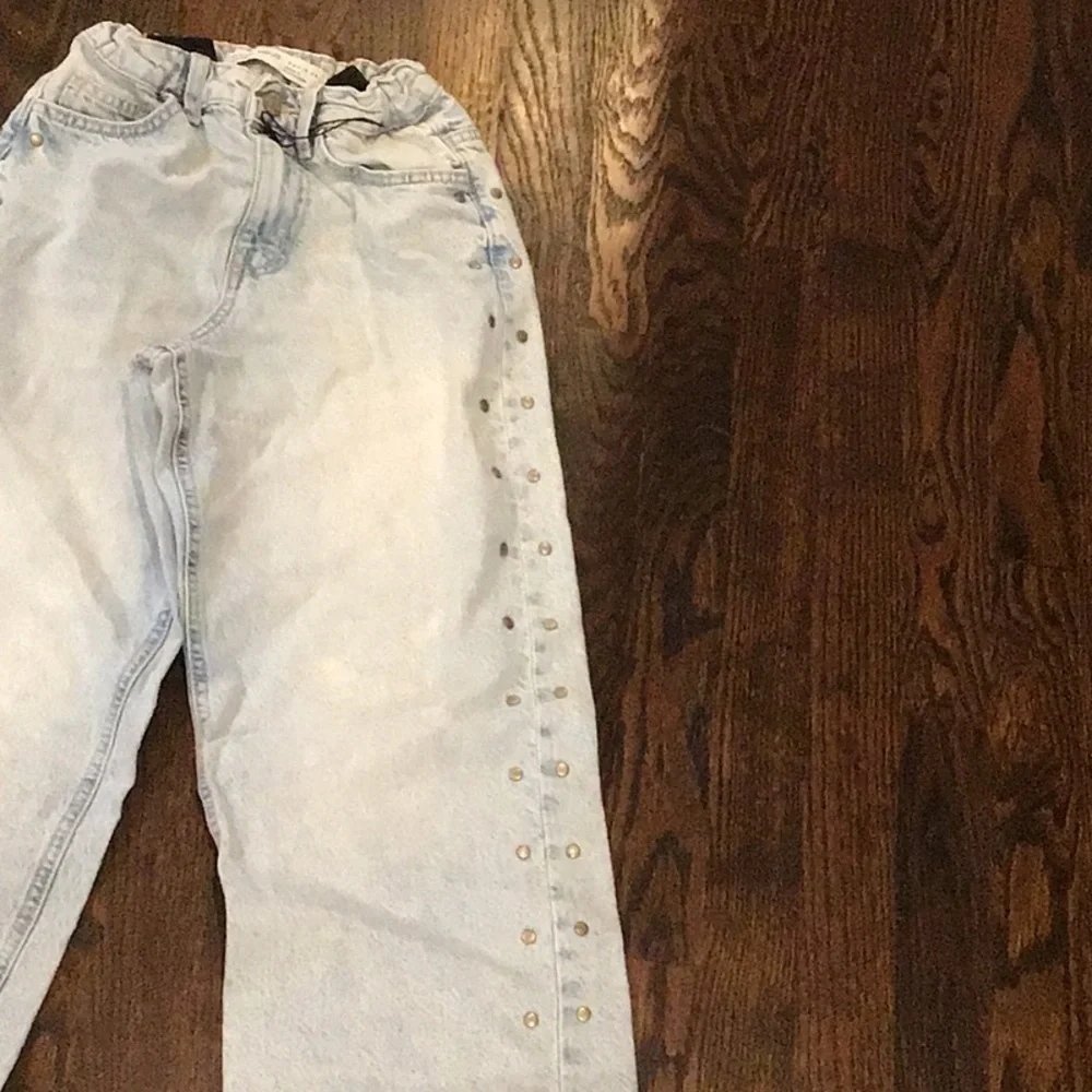 Primark - light-wash wide-leg jeans featuring side metal stud details.
